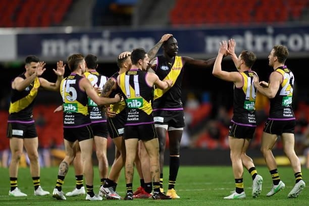 Mabior Chol of the Tigers celebrates with team mates after kicking a goal during the round 18 AFL match between the Richmond Tigers and the Brisbane...