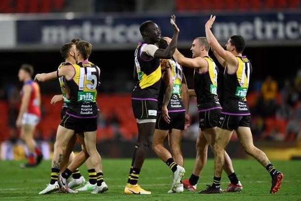Mabior Chol of the Tigers celebrates with team mates after kicking a goal during the round 18 AFL match between the Richmond Tigers and the Brisbane...
