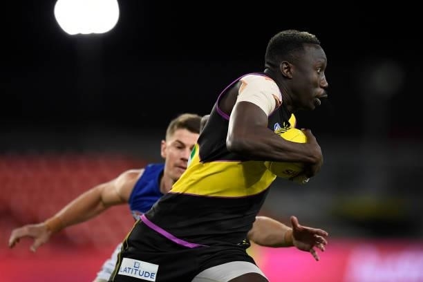 Mabior Chol of the Tigers gets past Dayne Zorko of the Lions during the round 18 AFL match between the Richmond Tigers and the Brisbane Lions at...