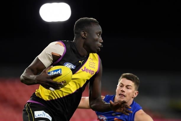 Mabior Chol of the Tigers gets past Dayne Zorko of the Lions during the round 18 AFL match between the Richmond Tigers and the Brisbane Lions at...