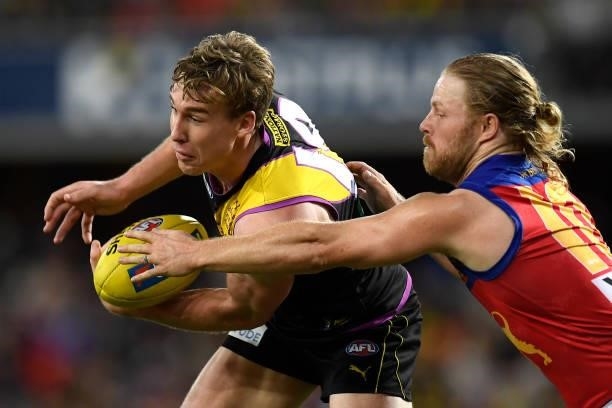 Tom Lynch of the Tigers is tackled by Daniel Rich of the Lions during the round 18 AFL match between the Richmond Tigers and the Brisbane Lions at...