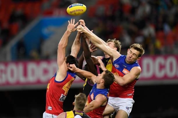 Players compete for the ball during the round 18 AFL match between the Richmond Tigers and the Brisbane Lions at Metricon Stadium on July 16, 2021 in...