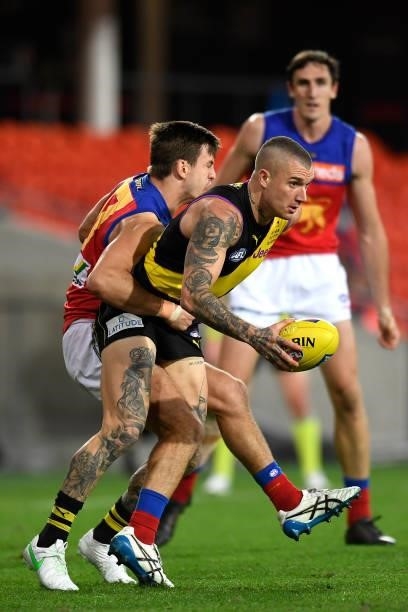 Dustin Martin of the Tigers is tackled during the round 18 AFL match between the Richmond Tigers and the Brisbane Lions at Metricon Stadium on July...