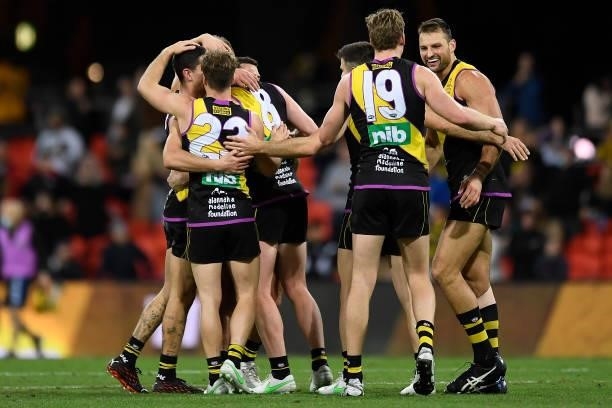 Richmond Tigers celebrate at the final siren during the round 18 AFL match between the Richmond Tigers and the Brisbane Lions at Metricon Stadium on...