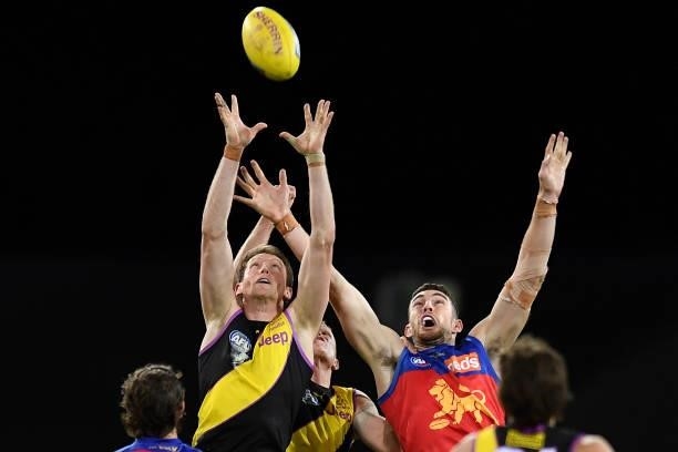 Dylan Grimes of the Tigers and Daniel McStay of the Lions compete for the ball during the round 18 AFL match between the Richmond Tigers and the...