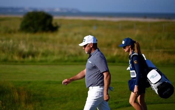 Lee Westwood of England and caddie walk on the 12th hole during Day Two of The 149th Open at Royal St George’s Golf Club on July 16, 2021 in...