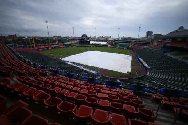 Tarp covers the infield as Toronto Blue Jays players warm up before the game against the Texas Rangers at Sahlen Field on July 16, 2021 in Buffalo,...