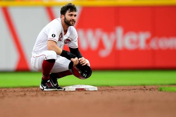 Tyler Naquin of the Cincinnati Reds kneels by second base after a double in the first inning during their game against the Milwaukee Brewers at Great...