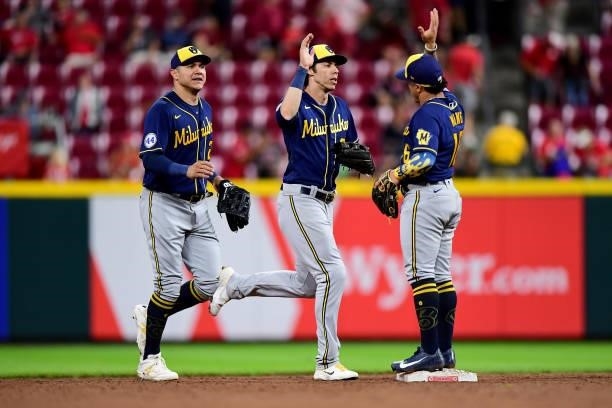 Christian Yelich celebrates with Kolten Wong of the Milwaukee Brewers after their 11-6 win over the Cincinnati Reds at Great American Ball Park on...