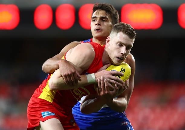 Josh Corbett of the Suns is challenged by Jamarra Ugle-Hagan of the Bulldogs during the round 18 AFL match between Gold Coast Suns and Western...