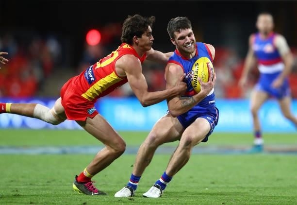 Taylor Duryea of the Bulldogs is challenged by Wil Powell of the Suns during the round 18 AFL match between Gold Coast Suns and Western Bulldogs at...