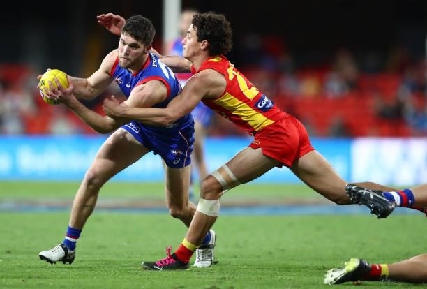 Taylor Duryea of the Bulldogs is challenged by Wil Powell of the Suns during the round 18 AFL match between Gold Coast Suns and Western Bulldogs at...