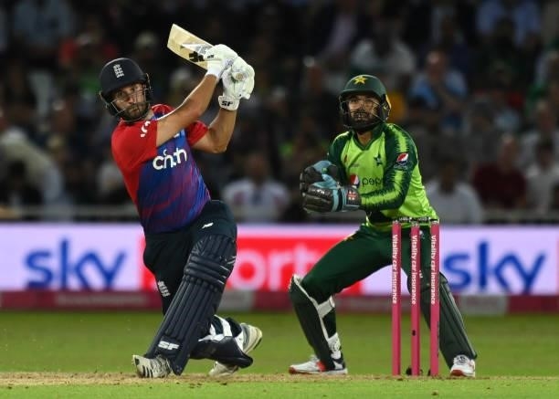 Lewis Gregory of England hits a six to reach his 100 as Pakistan wicket keeper Mohammad Rizwan looks on during the first Vitality International T20...