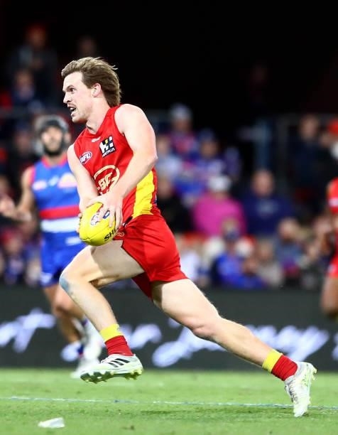 Noah Anderson of the Suns runs with the ball during the round 18 AFL match between Gold Coast Suns and Western Bulldogs at Metricon Stadium on July...