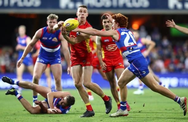 Josh Corbett of the Suns handballs during the round 18 AFL match between Gold Coast Suns and Western Bulldogs at Metricon Stadium on July 17, 2021 in...