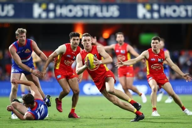 Josh Corbett of the Suns runs with the ball during the round 18 AFL match between Gold Coast Suns and Western Bulldogs at Metricon Stadium on July...