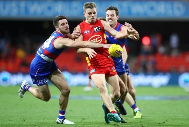 Nick Holman of the Suns attempts to get his kick away during the round 18 AFL match between Gold Coast Suns and Western Bulldogs at Metricon Stadium...