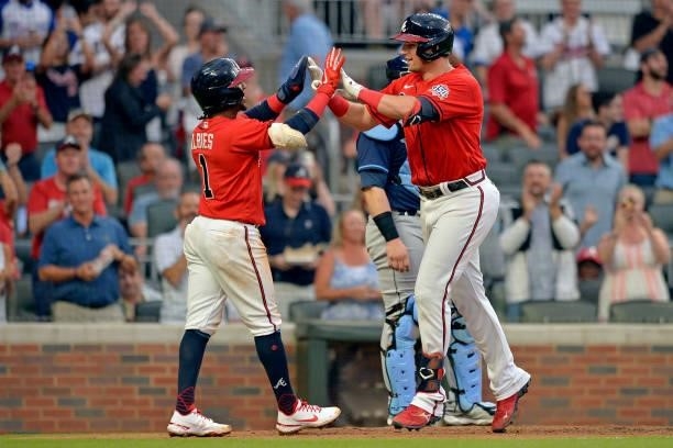 Ozzie Albies and Austin Riley of the Atlanta Braves celebrate at home plate during a game against the Tampa Bay Rays at Truist Park on July 16, 2021...