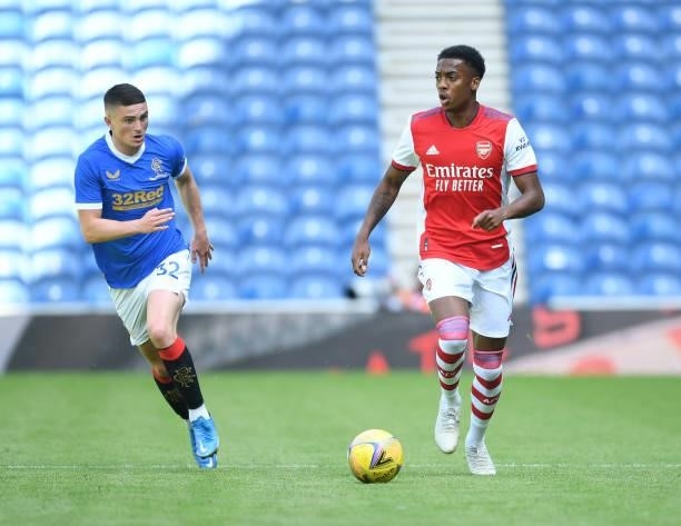 Joe Willock of Arsenal takes on Jake Hastie Rangers during the pre season friendly between Rangers and Arsenal at Ibrox Stadium on July 17, 2021 in...