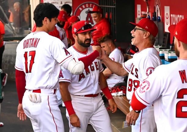 Shohei Ohtani in the dugout with first base coach Bruce Hines of the Los Angeles Angels before the game against the Seattle Mariners at Angel Stadium...