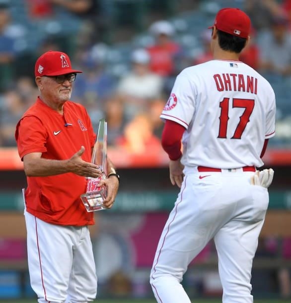 Shohei Ohtani was presented with American League Player of the Month award by manager Joe Maddon of the Los Angeles Angels before the game against...