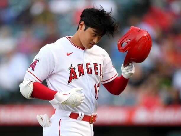 Shohei Ohtani of the Los Angeles Angels removes his batting helmet after striking out in the first inning of the game against the Seattle Mariners at...