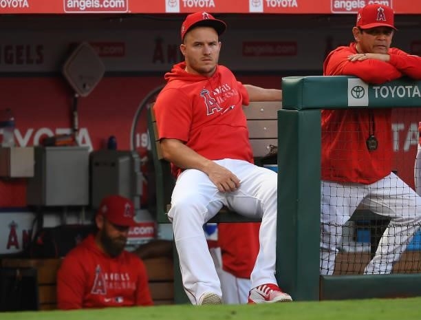 Mike Trout of the Los Angeles Angels looks on from the dugout in the fourth inning of the game against the Seattle Mariners at Angel Stadium of...