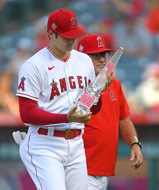 Shohei Ohtani was presented with American League Player of the Month award by manager Joe Maddon of the Los Angeles Angels before the game against...