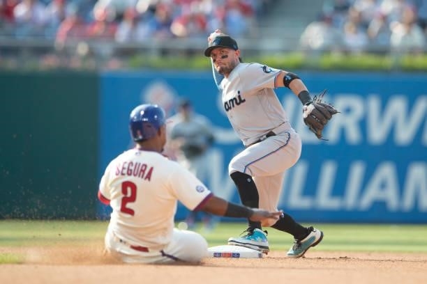 Miguel Rojas of the Miami Marlins attempts to turn a double play against Jean Segura of the Philadelphia Phillies during Game One of the doubleheader...