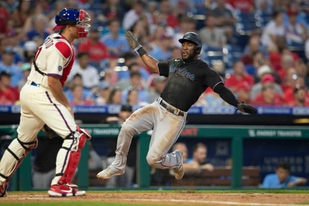 Starling Marte of the Miami Marlins slides home safely to score a run in the top of the third inning against the Philadelphia Phillies during Game...