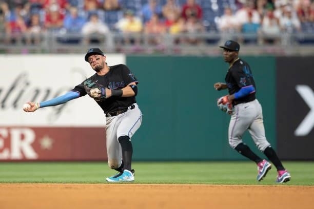 Miguel Rojas of the Miami Marlins throws the ball to first base as Jazz Chisholm Jr. #2 looks on against the Philadelphia Phillies during Game Two of...