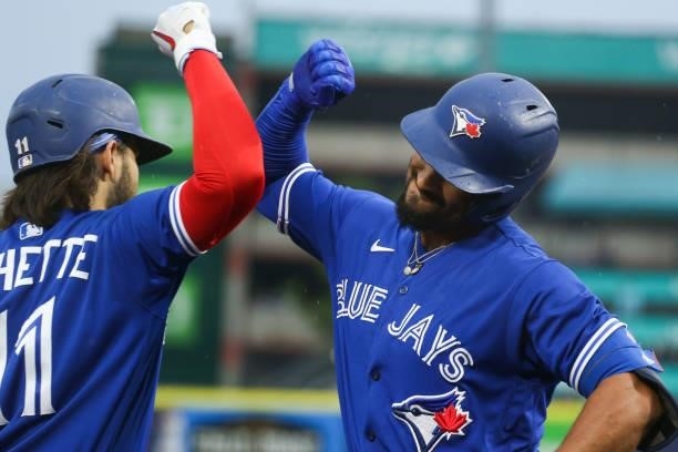 Marcus Semien of the Toronto Blue Jays celebrates with Bo Bichette after Semien hit a home run during the third inning against the Texas Rangers at...