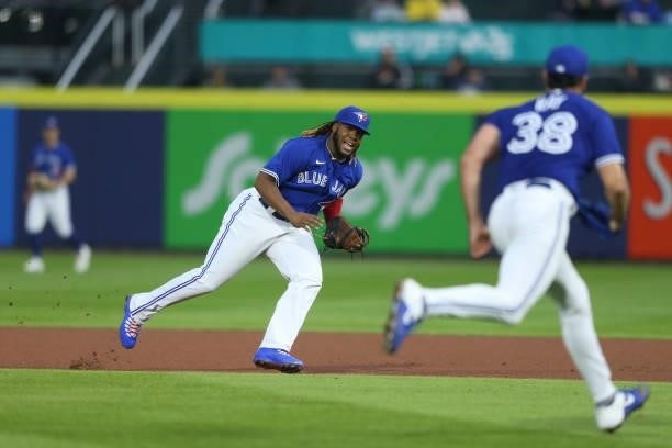 Vladimir Guerrero Jr. #27 of the Toronto Blue Jays runs to first base after fielding a ground ball by Jonah Heim of the Texas Rangers during the...