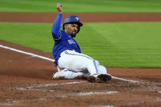 Marcus Semien of the Toronto Blue Jays slides to score on a RBI single by Bo Bichette during the fourth inning against the Texas Rangers at Sahlen...