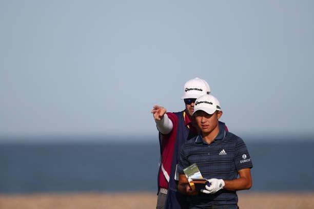 Collin Morikawa of the United States talks with caddie Jonathan Jakovac talk on the 13th tee during Day Three of The 149th Open at Royal St George’s...