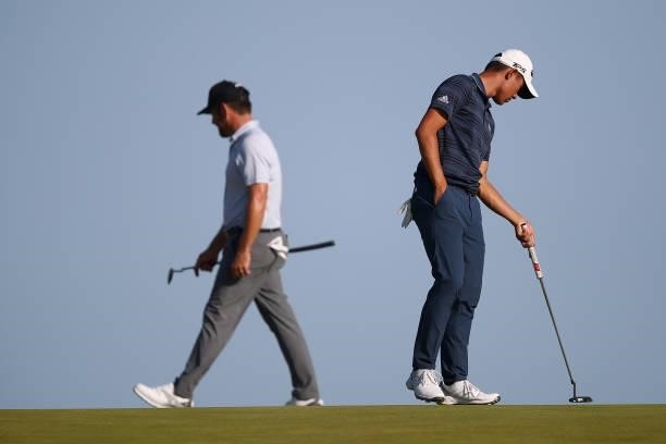 Louis Oosthuizen of South Africa and Collin Morikawa of the United States stand on the tenth green during Day Three of The 149th Open at Royal St...