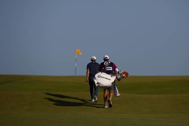 Collin Morikawa of the United States and his caddie Jonathan Jakovac walk to the tenth green during Day Three of The 149th Open at Royal St George’s...