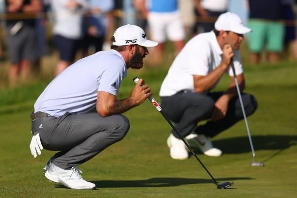 Dustin Johnson of The United States and Scottie Scheffler of United States line up putts during Day Three of The 149th Open at Royal St George’s Golf...