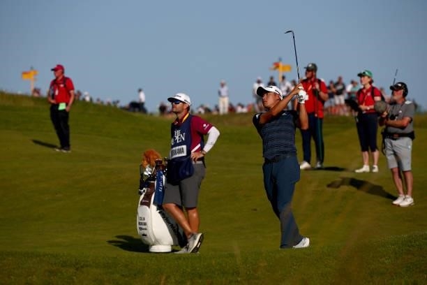 Collin Morikawa of the United States plays a shot on the ninth hole as caddie Jonathan Jakovac looks on during Day Three of The 149th Open at Royal...
