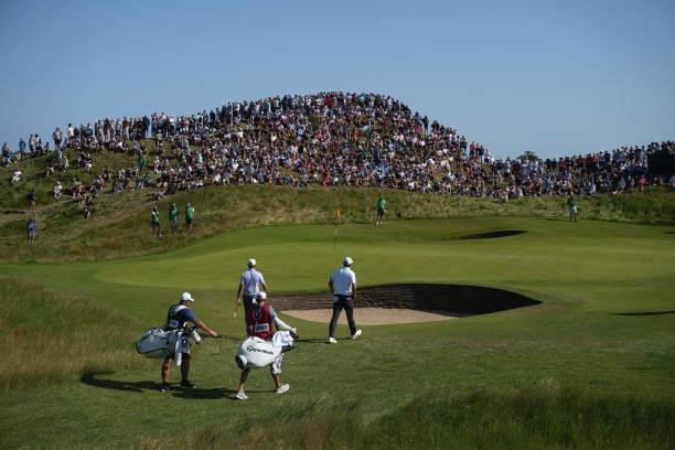 Dustin Johnson of the United States and Scottie Scheffler of the United States walk to the sixth green during Day Three of The 149th Open at Royal St...