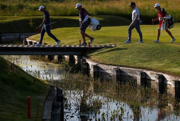 Collin Morikawa of the United States and Louis Oosthuizen of South Africa make their way over a bridge on the 14th hole during Day Three of The 149th...