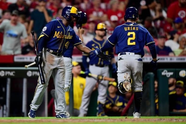 Jackie Bradley Jr. #41 high fives Luis Urias of the Milwaukee Brewers during a game between the Milwaukee Brewers and Cincinnati Reds at Great...