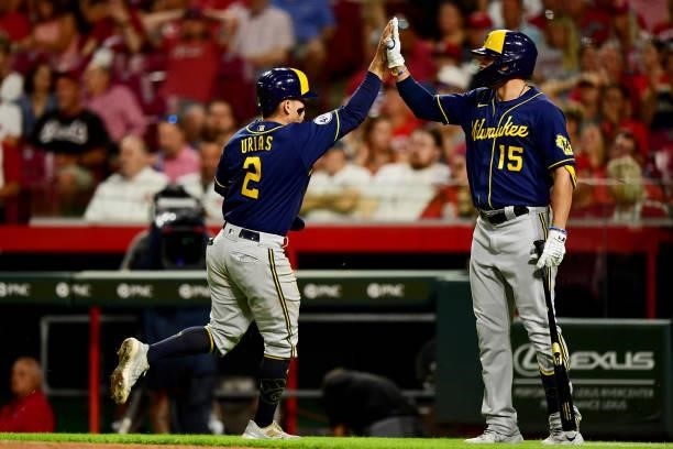 Tyrone Taylor high fives Luis Urias of the Milwaukee Brewers during a game between the Milwaukee Brewers and Cincinnati Reds at Great American Ball...