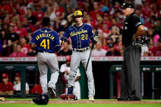 Christian Yelich high fives Jackie Bradley Jr. #41 of the Milwaukee Brewers during a game between the Milwaukee Brewers and Cincinnati Reds at Great...