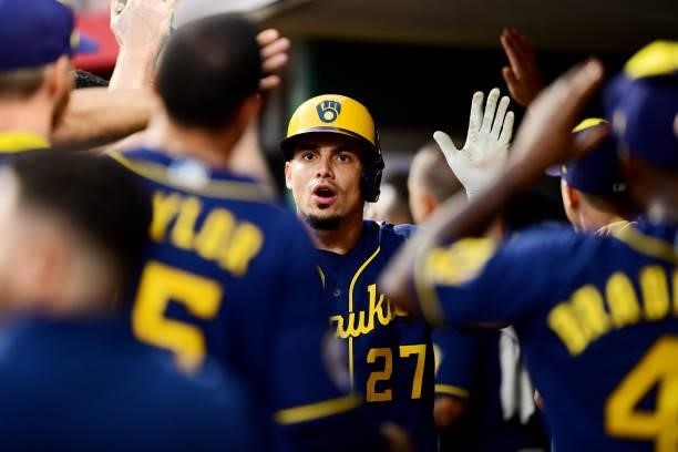 Willy Adames of the Milwaukee Brewers celebrates in the dugout during a game between the Milwaukee Brewers and Cincinnati Reds at Great American Ball...