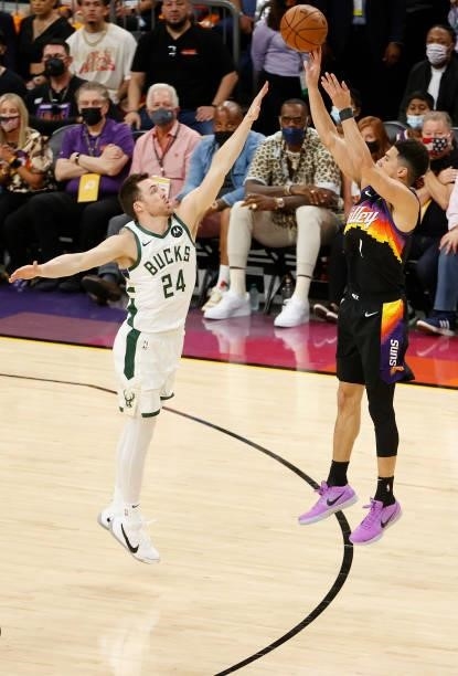Devin Booker of the Phoenix Suns shoots a three point shot against Pat Connaughton of the Milwaukee Bucks during the first half in Game Five of the...