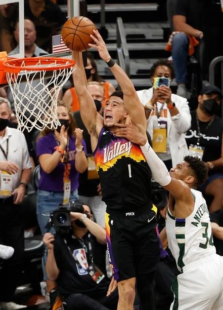 Giannis Antetokounmpo of the Milwaukee Bucks fouls Devin Booker of the Phoenix Suns during the first half in Game Five of the NBA Finals at Footprint...