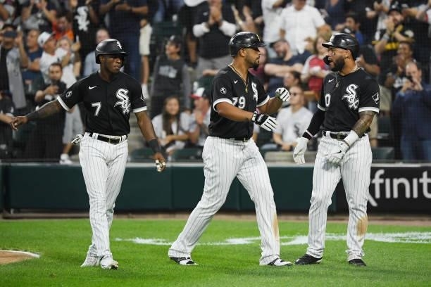 Jose Abreu of the Chicago White Sox celebrates with teammates Yoan Moncada and Tim Anderson after hitting a three-run home run in the sixth inning...