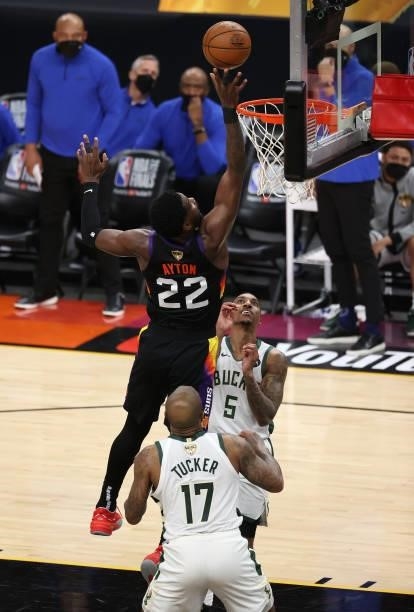 Deandre Ayton of the Phoenix Suns goes up for a shot against Jeff Teague and P.J. Tucker of the Milwaukee Bucks during the first half in Game Five of...