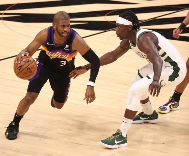 Chris Paul of the Phoenix Suns brings the ball up court against Jrue Holiday of the Milwaukee Bucks during the first half in Game Five of the NBA...